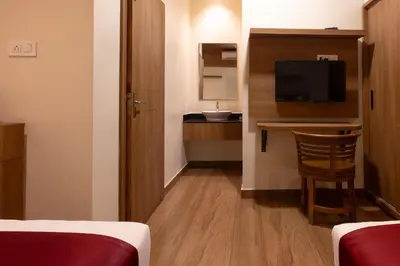 a hotel room with a television and a desk with a chair at MEDLEY REGENCY in Palakkad