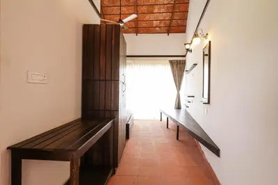 a hallway with a bench and a window at Havon Plantation Resorts in Varagampadi
