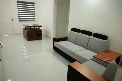 a living room with a couch and a table at Yelza Hotel and Residence in Alwaye