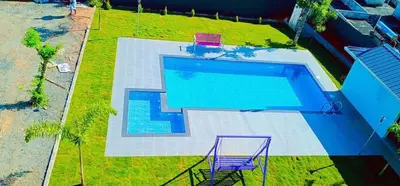 an overhead view of a swimming pool with two purple chairs at The Lavender Resort Waynad in Vaduvanchal