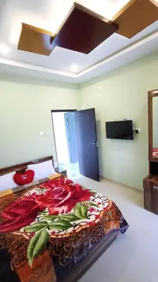 a bedroom with a bed with a bedspread with flowers on it at Rose Garden Enclave for Families & Executives in Ooty