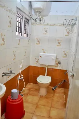 a bathroom with a toilet and a sink at Down House 19 Ooty - TEYT HOLIDAYS in Ooty