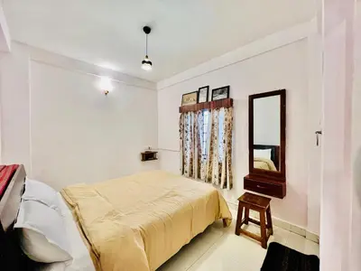 a bedroom with a bed and a mirror at Down House 19 Ooty - TEYT HOLIDAYS in Ooty