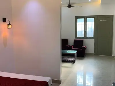 a room with a bed and a chair and a table at FAAZ Residency in Kozhikode