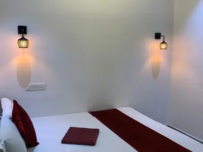 a bedroom with a bed with two lights on it at FAAZ Residency in Kozhikode