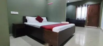 a bedroom with a large bed with a red blanket at FAAZ Residency in Kozhikode