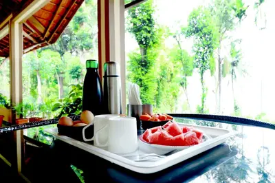 a tray with fruit on a table in front of a window at SaffronStays Coorg Toddy Farms, Coorg in Madikeri