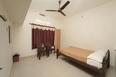 a bedroom with a bed and a ceiling fan at JUNGLE PARADISE FARM & GUEST HOUSE in Masinagudi