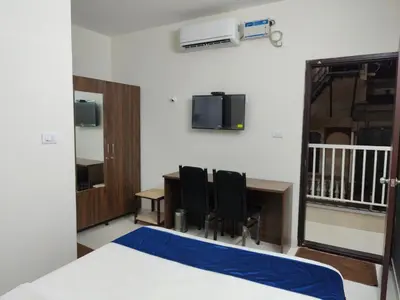 a room with a desk and two chairs and a table at Minimal Poshtel in Mysore