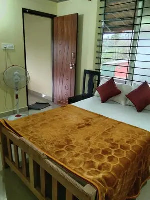a bedroom with a large bed with a wooden frame at SAMZ ESTATE Stay 3BHK in Madikeri