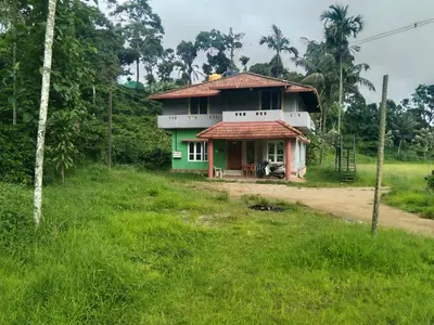 a small house in the middle of a field at SAMZ ESTATE Stay 3BHK in Madikeri