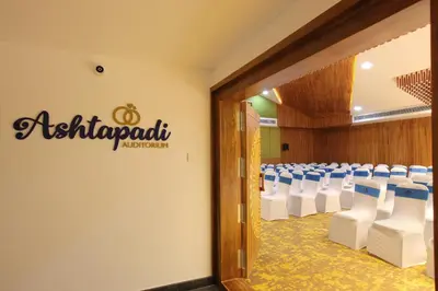 a conference room with white chairs and a sign on the wall at Harivaram Yuga in Guruvāyūr