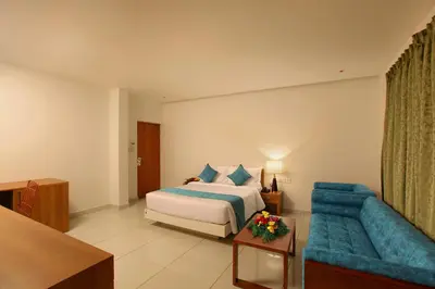 a hotel room with a bed and a blue couch at Harivaram Yuga in Guruvāyūr