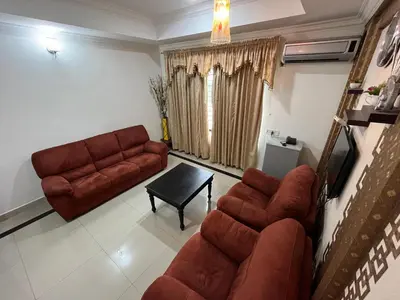 a living room with a couch and a table at Gee Bee Palace in Angamali