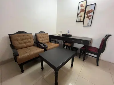 a room with a desk and two chairs and a table at Gee Bee Palace in Angamali