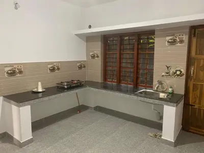 a kitchen with a sink and a counter top at Shivalaya Homestay in Madikeri