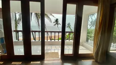 an open door with a view of the ocean from a house at Willo Stays On the beach Sea view Ocean Hues holiday home in Kannur