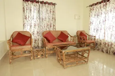 a living room with two chairs and a table at Toms Villa along National highway Thrissur at Nadathara in Trichūr
