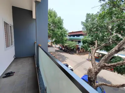 a balcony with a tree on the side of a building at Meer Stay - Premium Service Apartments in Vānivilāsa Puram