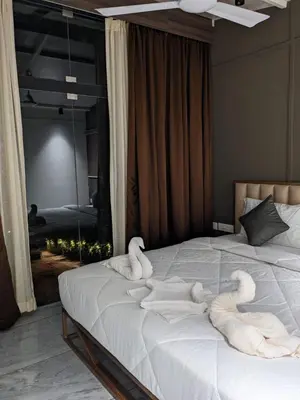 a bedroom with two swan towels on a bed at Miracle Hotel and Resorts in Kozhikode