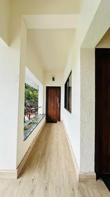 a hallway with a door and a wooden floor at Wild Elephant Resort in Kallar Vattiyar