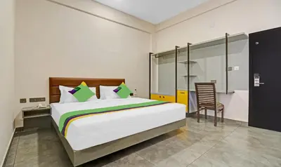 a bedroom with a large bed and a chair at Treebo Grand Vistara Airport Suites in Cochin