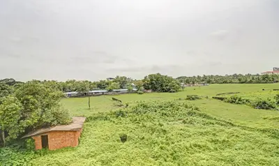 a small brick building in a field of grass at Treebo Grand Vistara Airport Suites in Cochin