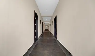 an empty hallway with white walls and a tile floor at Treebo Grand Vistara Airport Suites in Cochin