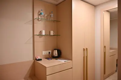 a room with a kitchen with a counter and a refrigerator at Soho Boutique Hotel in Mysore