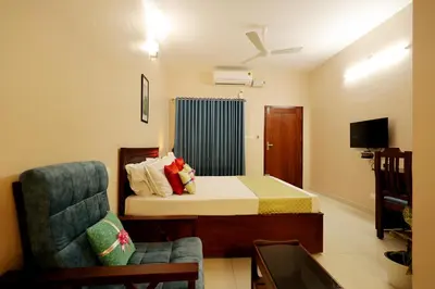 a small room with a bed and a chair at Isha Residency in Alwaye