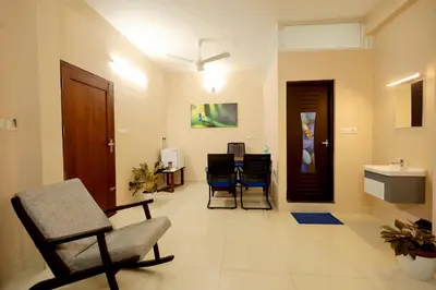 a living room with a chair and a table at Isha Residency in Alwaye