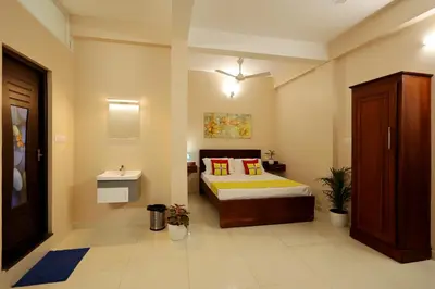a bedroom with a bed and a sink in it at Isha Residency in Alwaye