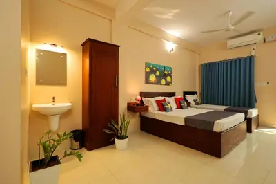 a bedroom with a bed and a sink in it at Isha Residency in Alwaye