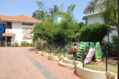 a boy playing on a playground in front of a building at Guruvayoor Resort in Guruvāyūr