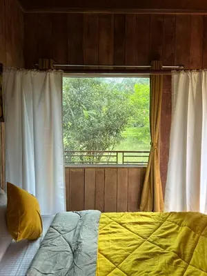 a bedroom with a bed and a window with a view at Cure Monastery Family Resort in Marayoor