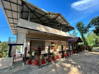 a house with potted plants on the side of it at Shivalaya Homestay, Madikeri in Siddapur