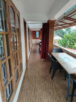 an empty hallway with a table and chairs in a building at Shivalaya Homestay, Madikeri in Siddapur
