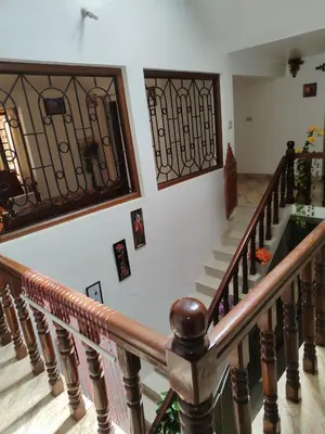 a staircase in a house with wrought iron railings at Shivalaya Homestay, Madikeri in Siddapur