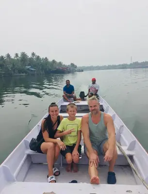 a family sitting in a boat on the water at Vala House - Full Villa in Pallipuram