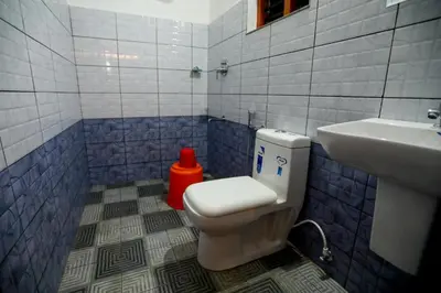 a bathroom with a toilet and a sink at Dakshinakasi Guest House in Thirunelli
