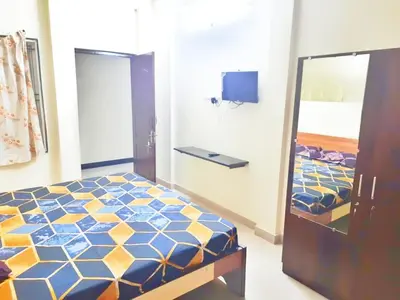a bedroom with a bed with a blue and yellow at HOTEL ROYAL PARADISE in Coimbatore
