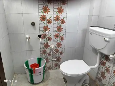 a bathroom with a toilet and a trash can at HOTEL ROYAL PARADISE in Coimbatore