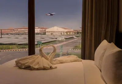 a bed with a towel on it with a window at Florida Airport Hotel Kochi in Nedumbassery