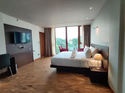 a hotel room with a bed and a flat screen tv at Florida Airport Hotel Kochi in Nedumbassery