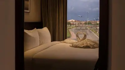 a bed in a hotel room with a window at Florida Airport Hotel Kochi in Nedumbassery