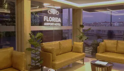 a lobby with two chairs and a sign that reads flida antipolis at Florida Airport Hotel Kochi in Nedumbassery