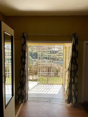 a room with a window with a view of a yard at Rustic 3-BR Villa w/ Front & Back Yards in the mountains in Ooty