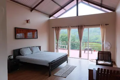 a bedroom with a bed and a large window at Biosphere in Coonoor
