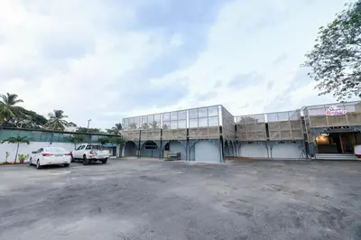 a building with cars parked in a parking lot at Shine Residency in Mysore