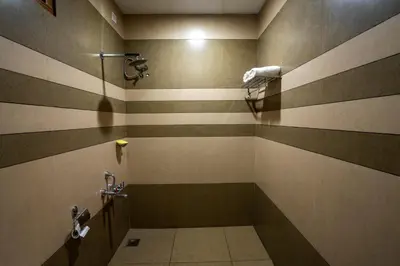 a bathroom with brown and tan stripes on the wall at Stephen's Legacy in Vattavada